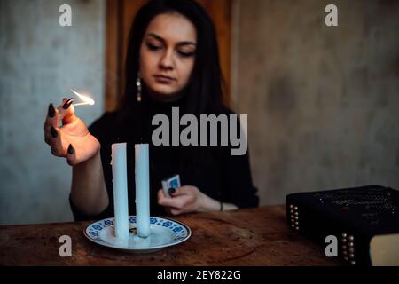 une fille de fortune teller allume des bougies pour prédire l'avenir. rituel mystique de la communication avec les esprits Banque D'Images