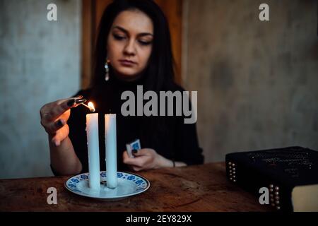 une fille de fortune teller allume des bougies pour prédire l'avenir. rituel mystique de la communication avec les esprits Banque D'Images