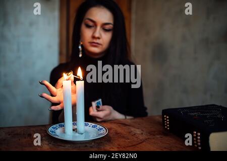 une fille de fortune teller allume des bougies pour prédire l'avenir. rituel mystique de la communication avec les esprits Banque D'Images