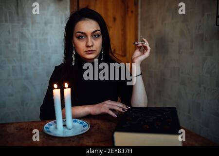 une fille de fortune teller allume des bougies pour prédire l'avenir. rituel mystique de la communication avec les esprits Banque D'Images