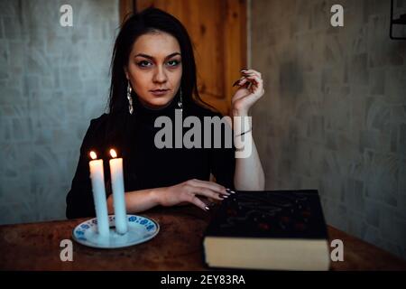 une fille de fortune teller allume des bougies pour prédire l'avenir. rituel mystique de la communication avec les esprits Banque D'Images