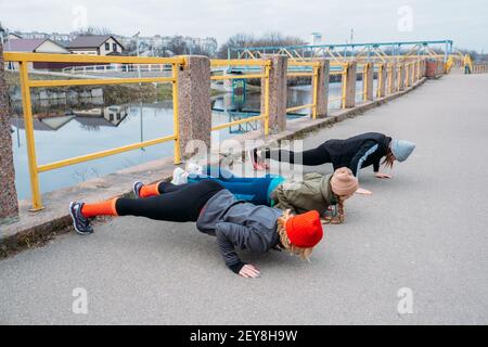 Cours de fitness en groupe à l'extérieur. Cours de gym organisés dans les parcs publics. Trois femmes s'entraîner ensemble dans le parc public. Santé Banque D'Images