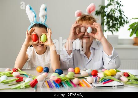 Concept de Pâques. La grand-mère avec sa petite-fille tient des œufs de Pâques à la maison Banque D'Images