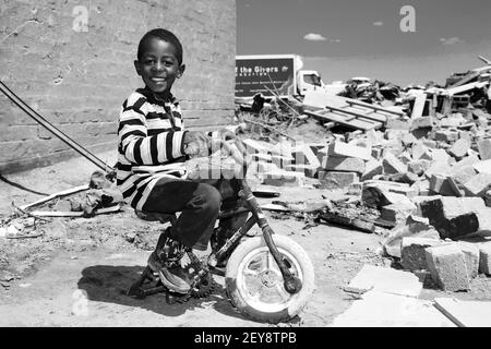 JOHANNESBURG, AFRIQUE DU SUD - 05 janvier 2021: Johannesburg, Afrique du Sud - octobre 04 2011: Un garçon africain dans un canton endommagé par la tornade Banque D'Images