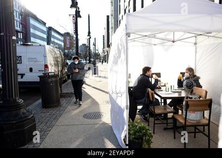 Washington, États-Unis. 5 mars 2021. Les gens s'assoient dans une tente de restaurant à Washington, DC, aux États-Unis, le 5 mars 2021. Les employeurs américains ont ajouté 379,000 emplois en février, le taux de chômage ayant peu changé à 6.2 p. 100, a indiqué vendredi le ministère du travail. En février, la plupart des gains d'emploi se sont produits dans les loisirs et l'accueil, avec des gains plus faibles dans les services d'aide temporaire, les soins de santé et l'aide sociale, le commerce de détail et la fabrication, selon le rapport mensuel publié par le Bureau de la statistique du travail du Ministère. Credit: Ting Shen/Xinhua/Alay Live News Banque D'Images