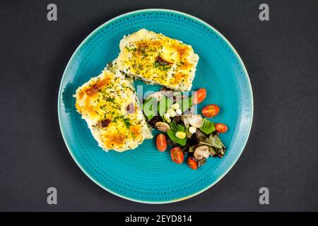 Lasagnes végétariennes recouvertes de pignons de pin grillés et de fromages à pâte. Avec salade et vin rouge. Banque D'Images