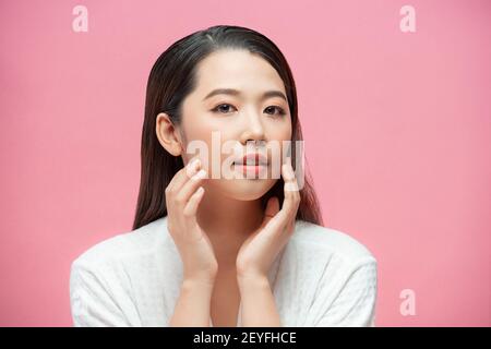 Concept beauté et spa. Belle jeune femme avec une peau propre et fraîche toucher propre visage et sourire Banque D'Images