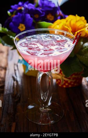 Cocktail cosmopolite garni de glace sur une table en bois Banque D'Images