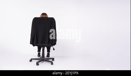 Bannière, format long. Vue arrière, fauteuil de bureau en cuir noir dans lequel une femme est assise. Beaucoup d'espace latéral pour vos textes ou annonces. Banque D'Images