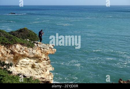 Sagres, Portugal: Janvier 2021; pêche de pêcheur à partir d'une falaise sur la côte ouest de l'Algarve, au Portugal Banque D'Images