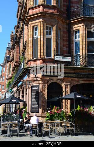 Les gens bavardent devant le pub Audley sur Mount Street/Audley Street, Mayfair, Londres, Angleterre Banque D'Images