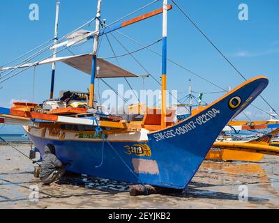 Travaux d'entretien sur un bateau de pêche traditionnel avec des stabilisateurs à Tinoto, un village de pêcheurs de Maasim, dans la province de Sarangani aux Philippines Banque D'Images