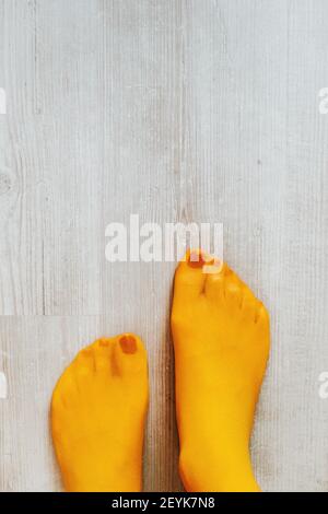 Femme portant des collants jaunes et des ongles de pointe de peinture rouge Banque D'Images