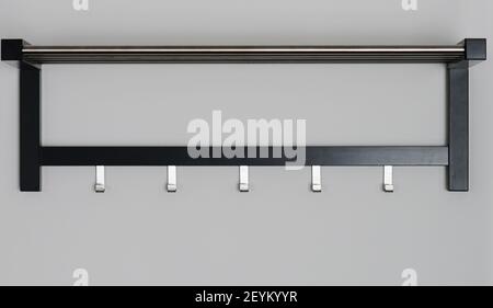 Cintre avec crochets métalliques isolés sur le mur blanc Banque D'Images