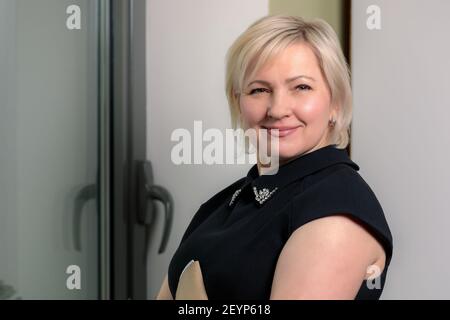 Une femme directrice travaillant au bureau se tient à la table avec un dossier contenant des documents. Gros plan. Banque D'Images