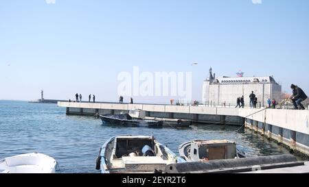 istanbul kadikoy personnes pêchant sur la rive en béton et petit et vieux bateau de pêche d'époque sur bosporus istanbul près de la gare centrale de haydarpasa. Banque D'Images