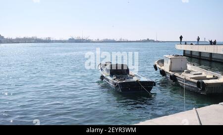 istanbul kadikoy personnes pêchant sur la rive en béton et petit et vieux bateau de pêche d'époque sur bosporus istanbul près de la gare centrale de haydarpasa. Banque D'Images