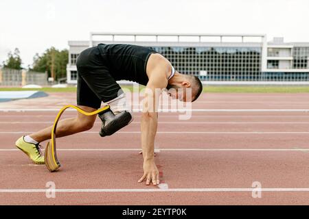 démarrez le coureur handicapé sur la jambe prothétique sur la piste du stade Banque D'Images