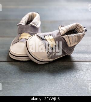 Chaussures douces pour bébé garçon sur parquet bleu. Enfants nouveau-nés, petite taille, chaussons bleus, vue rapprochée. Premières étapes Banque D'Images