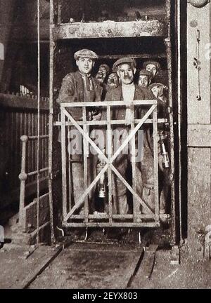 Une vieille photo (vers les années 1940) montrant des mineurs britanniques dans une cage à fosse arrivant à la façade de charbon. Banque D'Images