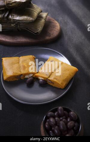 Plat typique du Pérou connu sous le nom de tamales, fait avec de la farine de maïs, poulet ou porc, ail, Chili, olives noires et oeuf. Banque D'Images