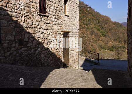 Un bâtiment en pierre avec une porte en bois dans un village médiéval italien (Marche, Italie, Europe) Banque D'Images