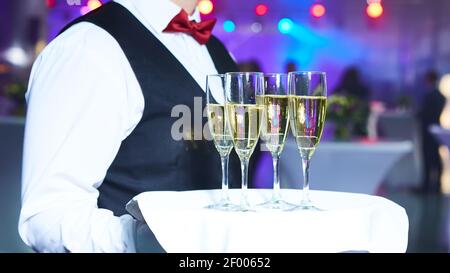 Waiter serving champagne sur un plateau Banque D'Images