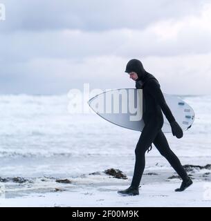 Surfeur d'aventure sur la plage de neige d'hiver Banque D'Images