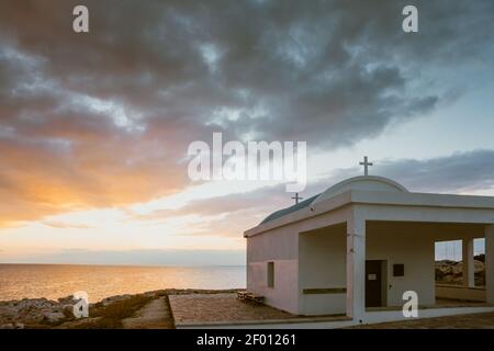 L'église Agioi Anargyeri au Cap Greco lever du soleil Mer Méditerranée côte Chypre. Banque D'Images