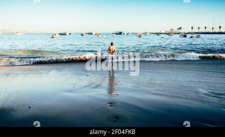 Une personne seule sur la plage par une journée ensoleillée à Cascais, Portugal Banque D'Images