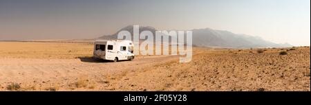 Voyage en voiture dans une maison de camping à travers la belle Damaraland, Namibie. Routes en gravier sans fin menant aux montagnes de Brandberg Banque D'Images