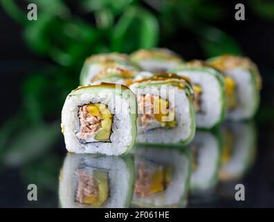 Vue macro de la cuisine japonaise Sushi Roll sur fond noir miroir. Menu du restaurant, bar à sushis Banque D'Images