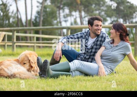 couple reposant sur l'herbe en automne dans une ferme Banque D'Images