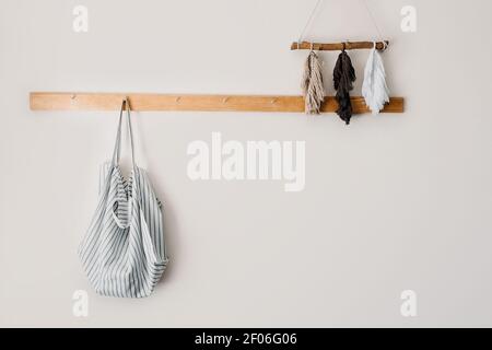 Maquette minimaliste dans des tons neutres avec sac fourre-tout écologique en coton biologique sur support en bois sur un mur gris. Zéro déchet, mode de vie durable, écologie Banque D'Images