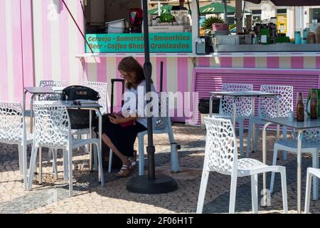 Faro, Portugal - avril 9 2020. Femme se reposant dans un bar chic à côté du port de Faro, en Algarve, en été. Banque D'Images