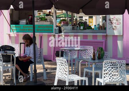 Faro, Portugal - avril 9 2020. Femme se reposant dans un bar chic à côté du port de Faro, en Algarve, en été. Banque D'Images