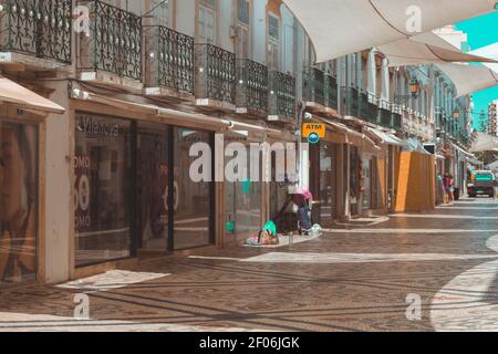 Faro, Portugal - avril 9 2020. Rue commerçante de Faro. Place au Portugal avec de mauvaises et peu de personnes dans la rue pour l'ombre lors d'une chaude journée d'été. Banque D'Images