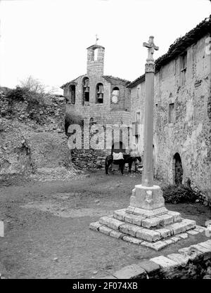 Plaça de Pilzán amb una creu de terme i dos cavalls, al fons un campanar. Banque D'Images