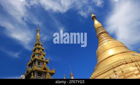 Deux temples dorés avec ciel bleu nuageux à l'intérieur de la Pagode Shwedagon Complexe à Yangoon Myanmar (Birmanie) Banque D'Images