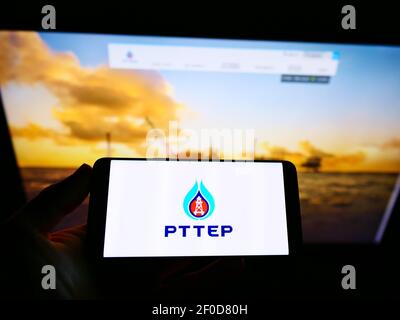 Personne tenant un smartphone avec le logo de la société thaïlandaise PTT exploration and production (PTTEP) à l'écran devant le site Web. Mise au point sur l'affichage du téléphone. Banque D'Images