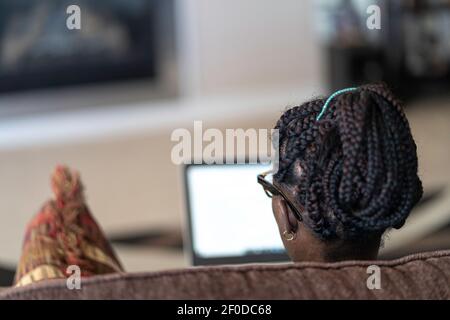 Femme nigériane afro-américaine travaillant sur son ordinateur portable depuis chez elle Banque D'Images
