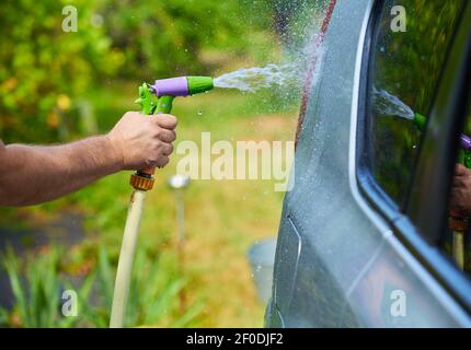 Les gens à l'aide de voiture nettoyage de l'eau haute pression Banque D'Images