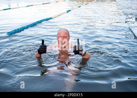 Vilnius, Lituanie. 6 mars 2021. Un nageur se met en mouvement lorsqu'il participe à une course de natation d'hiver sur le lac vert à Vilnius, en Lituanie, le 6 mars 2021. Une course de natation d'hiver de 25 mètres a eu lieu ici samedi. Credit: Alfredas Pliadis/Xinhua/Alamy Live News Banque D'Images