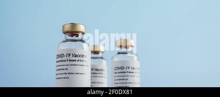 Flacons de vaccin Covid-19. Flacons de vaccin contre le coronavirus sur fond bleu. Banque D'Images