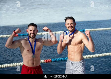 Vilnius, Lituanie. 6 mars 2021. Deux nageurs posent avec les médailles après une course de natation d'hiver sur le lac vert à Vilnius, Lituanie, le 6 mars 2021. Une course de natation d'hiver de 25 mètres a eu lieu ici samedi. Credit: Alfredas Pliadis/Xinhua/Alamy Live News Banque D'Images