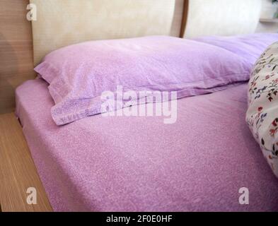 Lit défait le matin dans une chambre confortable Banque D'Images