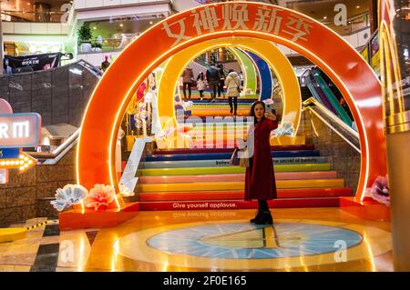 Une femme d’âge moyen prend un selfie devant un tunnel coloré pour la Journée des femmes dans le Super Brand Mall de Shanghai à Lujiazui, dans le district de Pudong, en Chine Banque D'Images