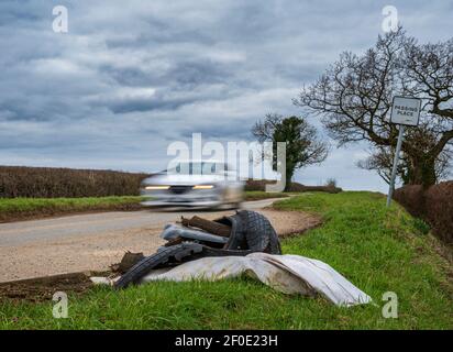 Leicestershire, Angleterre, Royaume-Uni – vol illégal sur une route à voie unique éloignée avec une voiture qui passe Banque D'Images