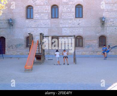 PARQUE INFANTIL CON LA FACHADA NORTE DE LA IGLESIA DE SAN VICENTE MARTIR DETRAS. Emplacement : EXTÉRIEUR. PARACUELLOS DEL JARAMA. MADRID. ESPAGNE. Banque D'Images