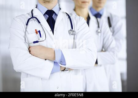 Groupe de médecins modernes debout comme une équipe avec des bras croisés et des stéthoscopes dans le bureau de l'hôpital. Médecins prêts à examiner et à aider les patients Banque D'Images